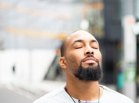 African American man closing eyes and feeling serene